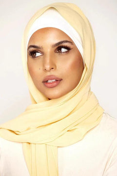 Georgette Hijab Online Pakistan, in pancake color. A woman wearing it with white top looking her right.