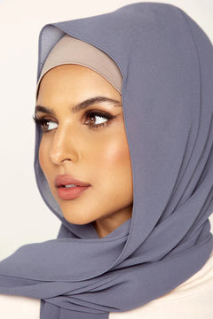 Georgette Hijab Online Pakistan, in denim grey color . a women wearing it with white top looking her right