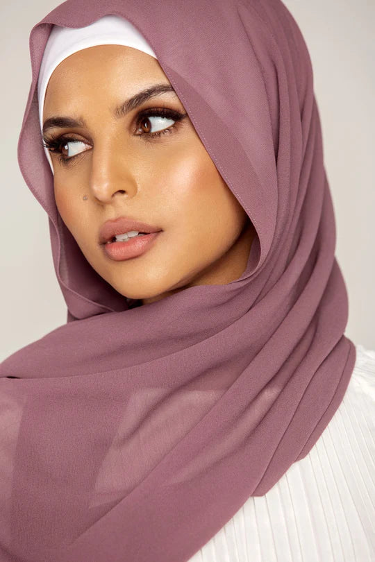 Georgette Hijab Online Pakistan, in dark mauve color . a women wearing it with white top looking her right