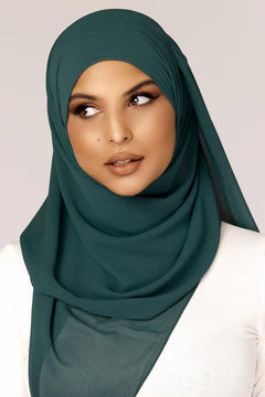 Georgette Hijab Online Pakistan, in Teal color. A woman wearing it with white top looking her right.