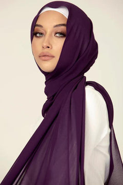 Georgette Hijab Online Pakistan, in eggplant color . a women wearing it with white top looking her right.