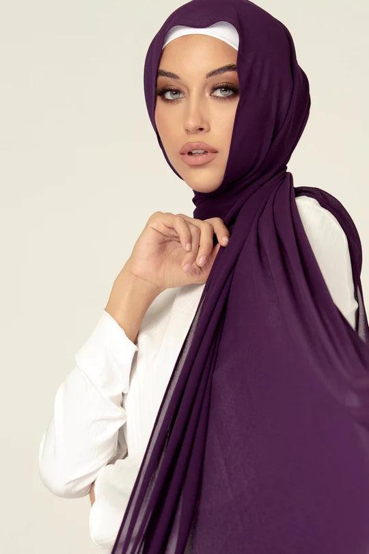 Georgette Hijab Online Pakistan, in eggplant color . a women wearing it with white top looking her straight.