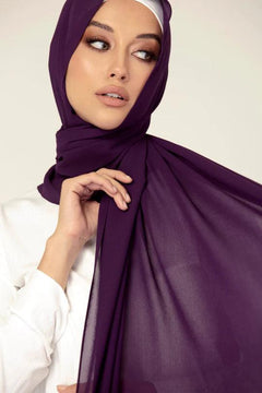 Georgette Hijab Online Pakistan, in eggplant color . a women wearing it with white top looking her right.