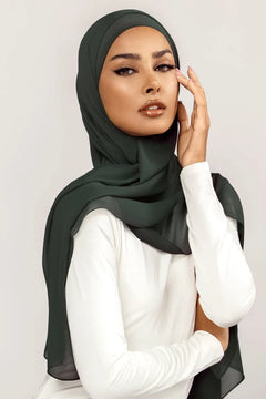 Georgette Hijab Online Pakistan, in bottle green color. A woman wearing it with white top looking her straight.