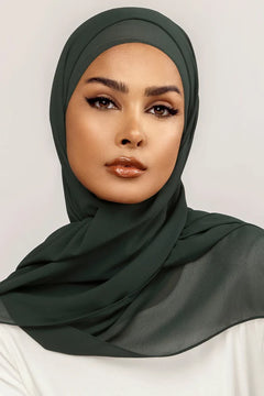 Georgette Hijab Online Pakistan, in bottle green color. A woman wearing it with white top looking her straight.