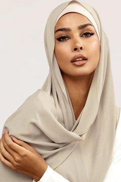 Georgette Hijab Online Pakistan, in pistachio grey color. A woman wearing it with white top looking her straight.