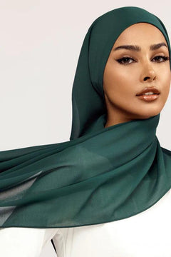 Georgette Hijab Online Pakistan, in peacock color . a women wearing it with white top looking her straight.