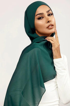 Georgette Hijab Online Pakistan, in peacock color . a women wearing it with white top looking her straight.