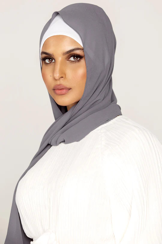 Georgette Hijab Online Pakistan, in smoke color . a woman wearing it with white top looking her straight.