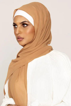 Georgette Hijab Online Pakistan, in golden brown color. A woman wearing it with white top looking her straight.