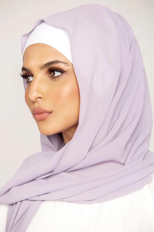 Georgette Hijab Online Pakistan, in preiwinkle color. A woman wearing it with white top looking her right.