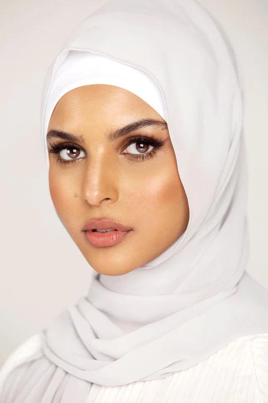 Georgette Hijab Online Pakistan, in light grey color. A woman wearing it with white top looking her straight.