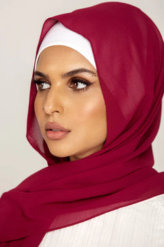 Georgette Hijab Online Pakistan, in cherry color . a women wearing it with white top looking her right.