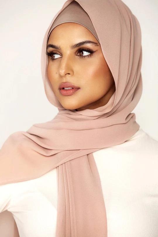 Georgette Hijab Online Pakistan, in khaki rose color. A woman wearing it with white top looking her right.