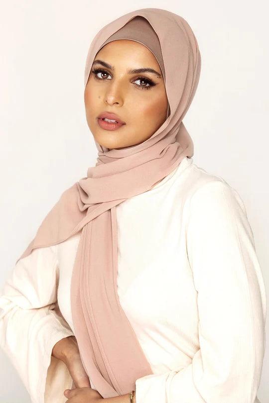 Georgette Hijab Online Pakistan, in khaki rose color. A woman wearing it with white top looking her straight.