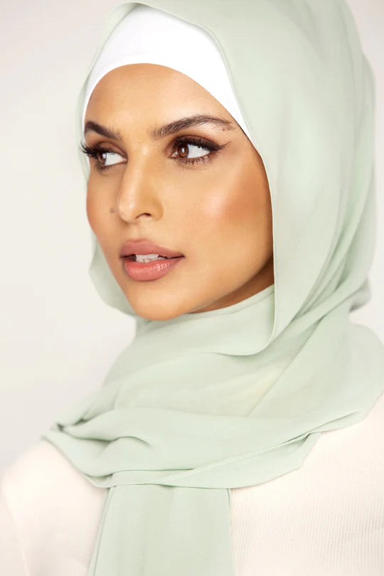 Georgette Hijab Online Pakistan, in light mint color . a women wearing it with white top looking her right