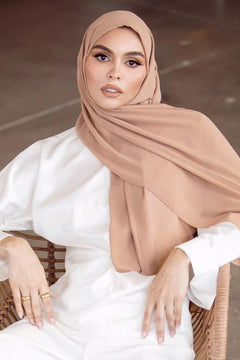 Girl Styling on chair in Georgette Hijab in beige looking straight.