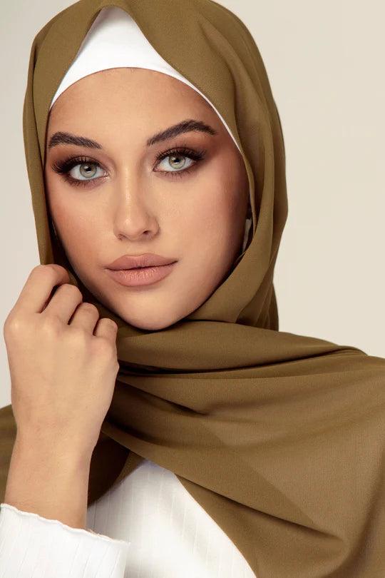 Georgette Hijab Online Pakistan, in tortilla color. A woman wearing it with white top looking her straight.