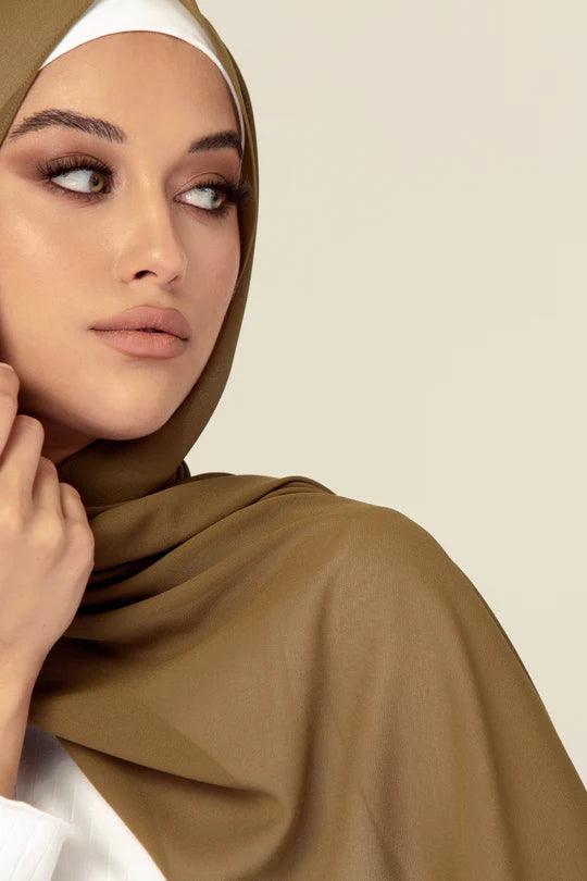 Georgette Hijab Online Pakistan, in tortilla color. A woman wearing it with white top looking her left.