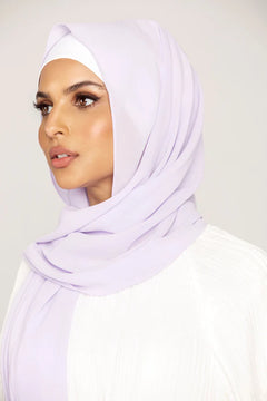 Georgette Hijab Online Pakistan, in lilac color. A woman wearing it with white top looking her right.