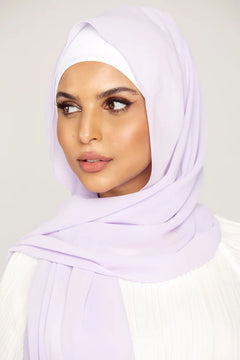 Georgette Hijab Online Pakistan, in lilac color. A woman wearing it with white top looking her right.