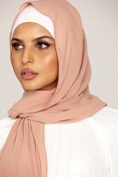 Georgette Hijab Online Pakistan, in blush color. A woman wearing it with white top looking her right.