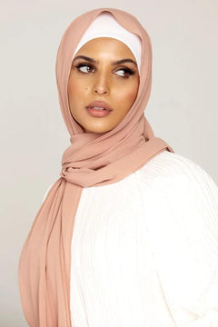 Georgette Hijab Online Pakistan, in blush color. A woman wearing it with white top looking her left.