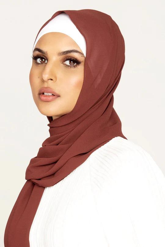 Georgette Hijab Online Pakistan, in sugar plum color. A woman wearing it with white top looking her straight.