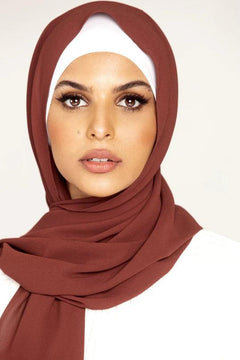 Georgette Hijab Online Pakistan, in sugar plum color. A woman wearing it with white top looking her straight.