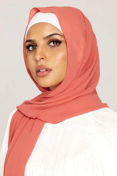 Georgette Hijab Online Pakistan, in flamingo color. A woman wearing it with white top looking her straight.