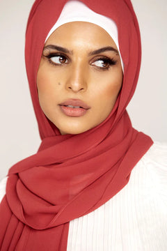 Georgette Hijab Online Pakistan, in velvet teddy color. A woman wearing it with white top looking her left.