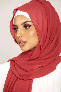 Georgette Hijab Online Pakistan, in velvet teddy color. A woman wearing it with white top looking her right.