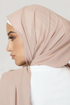 Georgette Hijab Online Pakistan, in sedona sand color . a women wearing it with white top looking her left. back view.