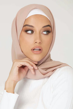 Georgette Hijab Online Pakistan, in sedona sand color . a women wearing it with white top looking her left.