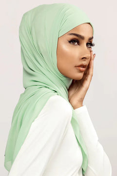 Georgette Hijab Online Pakistan, in mint green color. A woman wearing it with white top looking her right side profile.