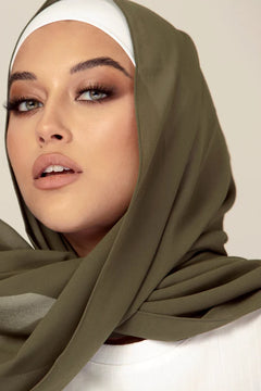 Georgette Hijab Online Pakistan, sage in color . a woman wearing it with white top.