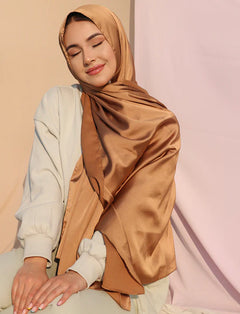 Stylish girl wearing satin silk hijab in copper color.