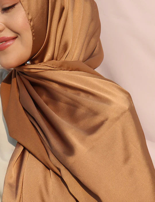 satin silk hijab in copper color. Stylish girl wearing hijab crafted from satin silk.